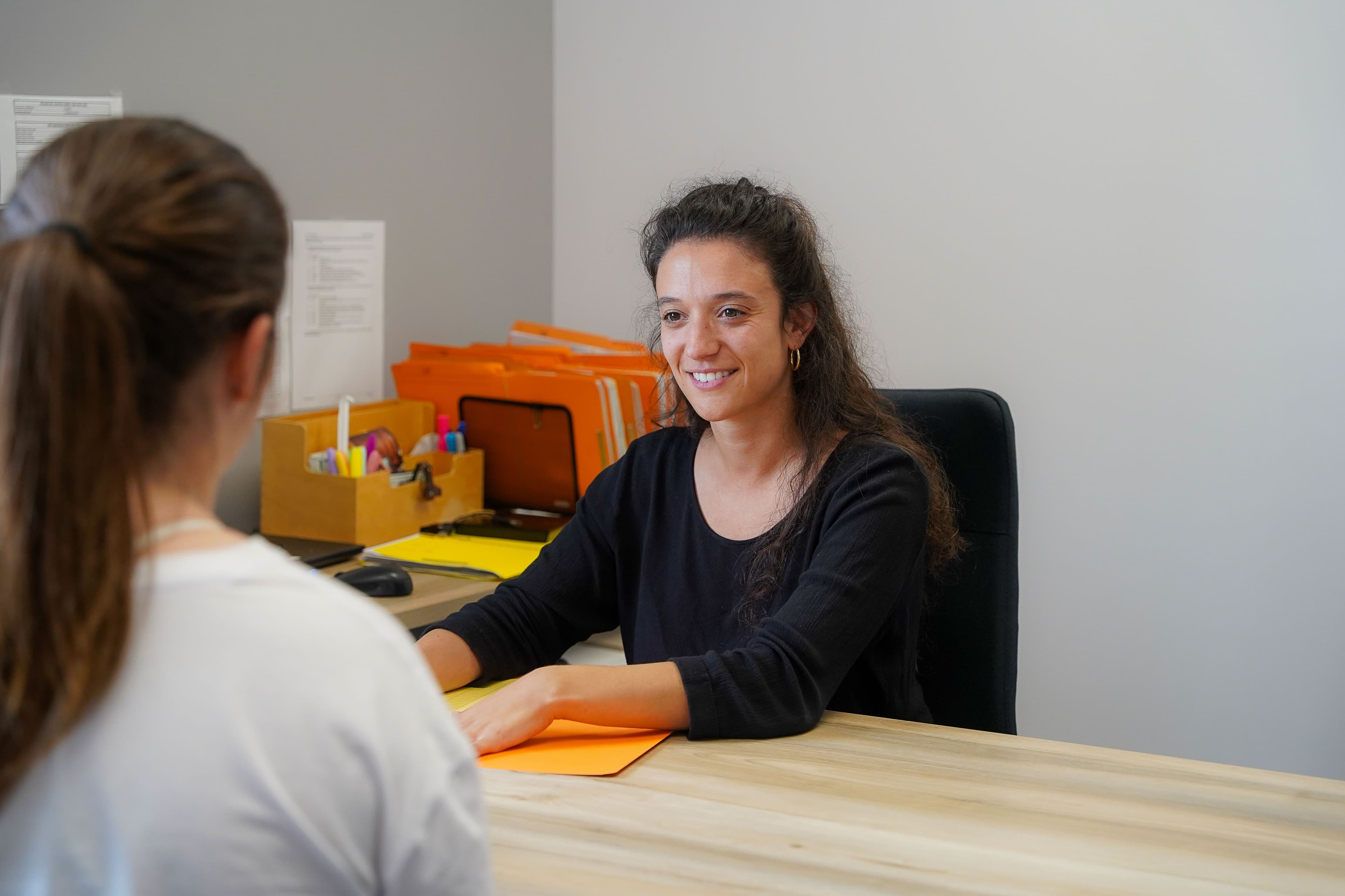 Deux personnes échangent dans un bureau.